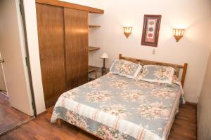 1 dormitorio con 1 cama y puerta de madera en Cabañas Las Añañucas II en La Serena