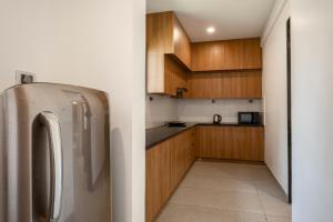 VeremSaffronStays Aqua的厨房配有不锈钢冰箱和木制橱柜