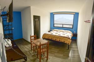 a bedroom with a bed and a chair and a window at OYO Casa Vieja,Ciudad Serdán,Museo La Magnolia in Ciudad Serdán