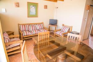 uma sala de estar com uma mesa de vidro e cadeiras em Cabañas Las Añañucas II em La Serena