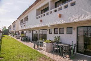 un bâtiment avec des tables et des chaises à l'extérieur dans l'établissement Cabañas Las Añañucas II, à La Serena