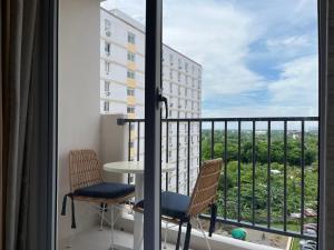 een balkon met 2 stoelen, een tafel en een raam bij Arastar Escape in Suba