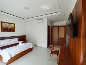 a bedroom with a bed and a flat screen tv at Artha Sadia Villa 1 Seseh Beach in Cemagi