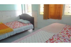 a bedroom with two beds and a window and a bedskirts at Nam Phuong Hostel 2 in Vung Tau +37 photos