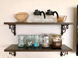 a shelf with four glass jars on it at The Little Garden - Vacation STAY 58431v in Miyazaki +9 photos