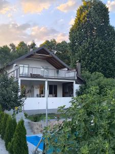 a white house with a balcony and a pool at Vila Đul in Konjic
