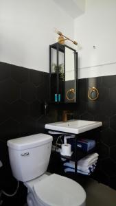 a bathroom with a white toilet and a sink at 1 & 2 Bedroom Apartments I Calle Loíza by Beach & Nightlife in San Juan