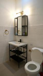 a bathroom with a toilet and a sink and a mirror at 1 & 2 Bedroom Apartments I Calle Loíza by Beach & Nightlife in San Juan +31 photos