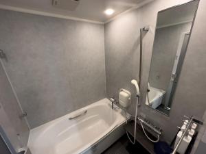 a bathroom with a tub and a sink and a mirror at SETO CLAS AJI - Vacation STAY 60217v in Sanuki