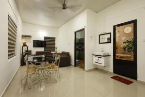 a living room with a table and chairs in a room at Anoop's Lake View Cottage -2BHK in Munroe Island
