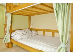 ein Schlafzimmer mit einem Etagenbett mit weißer Bettwäsche in der Unterkunft Okusuruga Guest House - Vacation STAY 14698 in Numazu