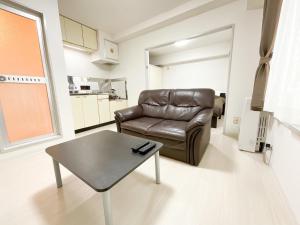 a living room with a leather couch and a table at E-Horizon Kita 2 Jo Building - Vacation STAY 15838 in Sapporo