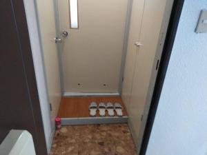 a small bathroom with a shower with four pairs of shoes at E-Horizon Kita 2 Jo Building - Vacation STAY 15838 in Sapporo