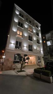 a large building with lights on it at night at Hotel La Favorita in Tirana +14 photos