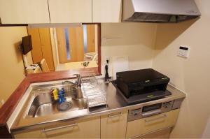 a kitchen with a sink and a microwave at Harmonia - Nest in Osaka - in Osaka