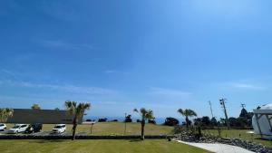 un grupo de coches estacionados en un estacionamiento con palmeras en amazing view room 2 - Vacation STAY 66283v, en Kushima