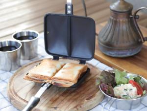 Un sándwich en una tabla de cortar con una ensalada y un cuchillo. en amazing view room 2 - Vacation STAY 66283v, en Kushima