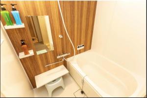 a bathroom with a white tub and a sink at Kyomachiya Mitsugetsu - Vacation STAY 63459v in Kyoto