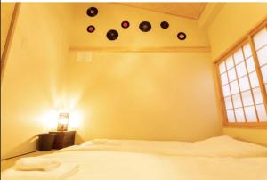 a bedroom with a bed and a shelf with clocks on the wall at Kyomachiya Mitsugetsu - Vacation STAY 63459v in Kyoto