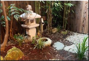 a garden with a bird bath and a fence at Kyomachiya Mitsugetsu - Vacation STAY 63459v in Kyoto