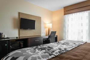 een hotelkamer met een bed en een flatscreen-tv bij Sleep Inn & Suites Marshall - University Area in Marshall