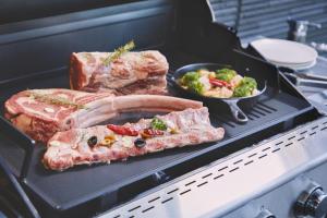 a grill with meat and a bowl of vegetables at Ocean Resort Tateyama A House - Vacation STAY 73416v in Tateyama