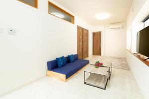 a living room with a blue couch and a tv at Akagawara no chiisana ouchi - Vacation STAY 72435v in Ishigaki Island
