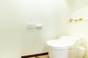 a white bathroom with a toilet and a roll of toilet paper at Akagawara no chiisana ouchi - Vacation STAY 72435v in Ishigaki Island