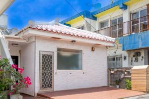 a small white house with a large garage at Akagawara no chiisana ouchi - Vacation STAY 72435v in Ishigaki Island