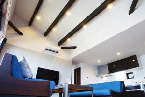 a living room with blue chairs and a tv at Ocean Resort Tateyama BBQ House - Vacation STAY 73564v in Tateyama
