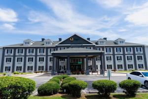 a large white building with a car parked in front of it at Quality Inn Rome South in Rome