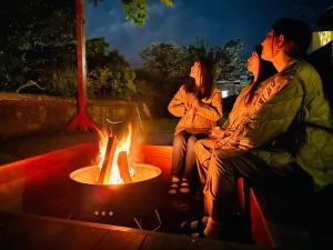 a couple of people sitting around a fire pit at Takabayashi Shoten Liquor store where you can stay - Vacation STAY 69075v in Oshima