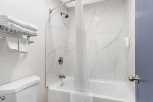 a white bathroom with a shower and a toilet at Quality Inn Madison - Huntsville in Madison