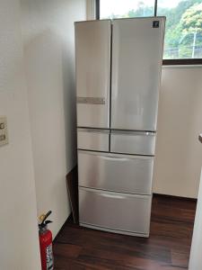 - un réfrigérateur en argent dans une cuisine avec fenêtre dans l'établissement Cliff top terrace - Vacation STAY 76503v, à Kuranomoto