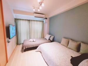 a small room with two beds and a couch at SY Mansion - Vacation STAY 15495 in Saitama