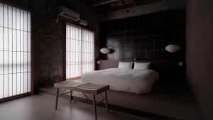 Un dormitorio con una cama y una mesa y ventanas. en Mud - Vacation STAY 71384v, en Ishigaki Island