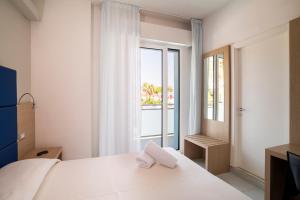 a bedroom with a white bed and a large window at Hotel Kon Tiki in Numana +39 photos