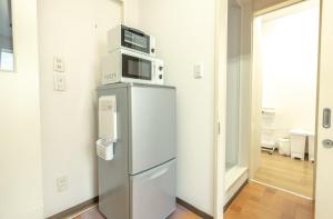 a microwave on top of a refrigerator in a room at Ezo Fujiya Niseko House - Vacation STAY 14768 in Kutchan