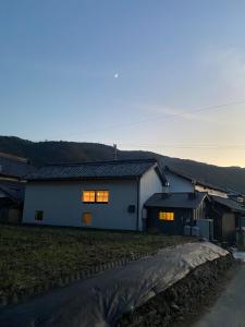 a white house with two windows and a road at Irori no Yado Kinoko - Vacation STAY 76611v in Sakaide