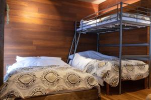 a bedroom with two bunk beds and a wooden wall at Sun Mall 3rd Mansion 602 - Vacation STAY 14779 in Tokyo