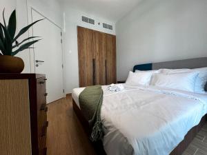 a bedroom with a large bed with a wooden door at Stylish 1BR on Al Maryah Skyline view Balcony in Abu Dhabi +14 photos