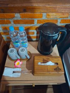 a table with a blender and bottles of water on it at Soluta Resort in Wainapal