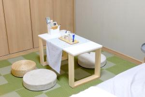 einen kleinen weißen Tisch mit einem Stuhl in einem Zimmer in der Unterkunft Daiichi Mitsumi Corporation - Vacation STAY 14915 in Musashino