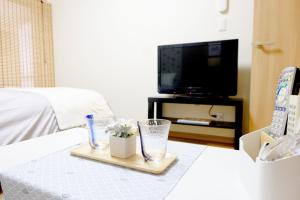 ein Wohnzimmer mit einem Tisch mit Blumen und einem Fernseher in der Unterkunft Daiichi Mitsumi Corporation - Vacation STAY 14915 in Musashino