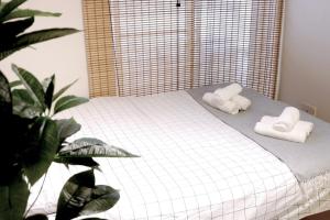 ein Schlafzimmer mit einem Bett mit Handtüchern darauf in der Unterkunft Daiichi Mitsumi Corporation - Vacation STAY 15232 in Musashino