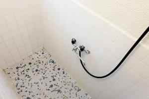 a shower with a hose in a bathroom at Daiichi Mitsumi Corporation - Vacation STAY 15348 in Musashino +8 photos