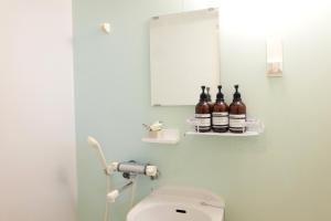 La salle de bains est pourvue de toilettes et de bouteilles sur une étagère. dans l'établissement Daiichi Mitsumi Corporation - Vacation STAY 16415, à Musashino 10 autres photos