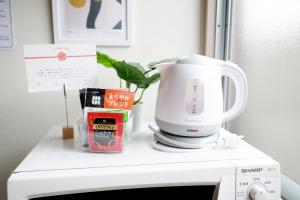 eine weiße Kaffeemaschine auf einer Mikrowelle in der Unterkunft Daiichi Mitsumi Corporation - Vacation STAY 15355 in Musashino
