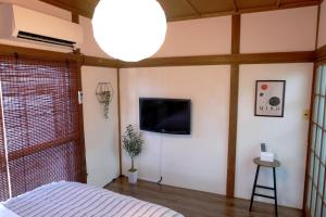 une chambre avec un lit et une télévision au mur dans l'établissement Daiichi Mitsumi Corporation - Vacation STAY 15266, à Musashino