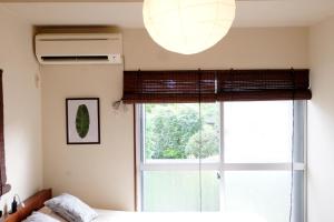 ein Schlafzimmer mit einem Fenster, einem Bett und einer Lampe in der Unterkunft Daiichi Mitsumi Corporation - Vacation STAY 15349 in Musashino